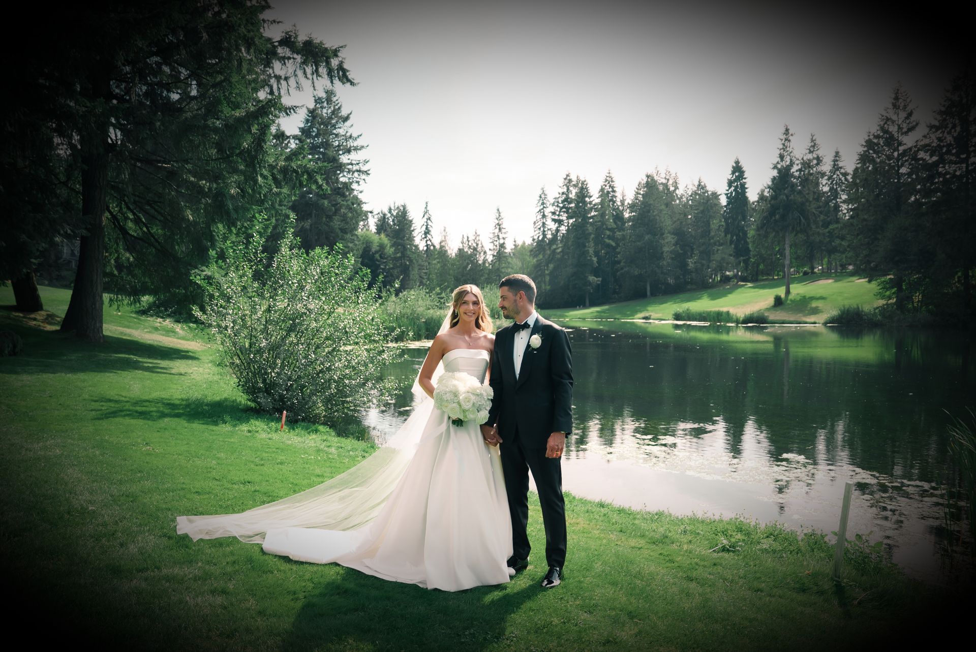 A couple by a lake on their wedding day